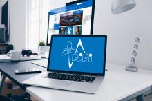 Notebook s logem KSI, na pozadí monitor s novým webem KSI